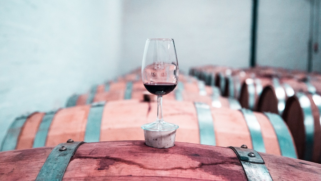 A glass of wine resting on a barrel